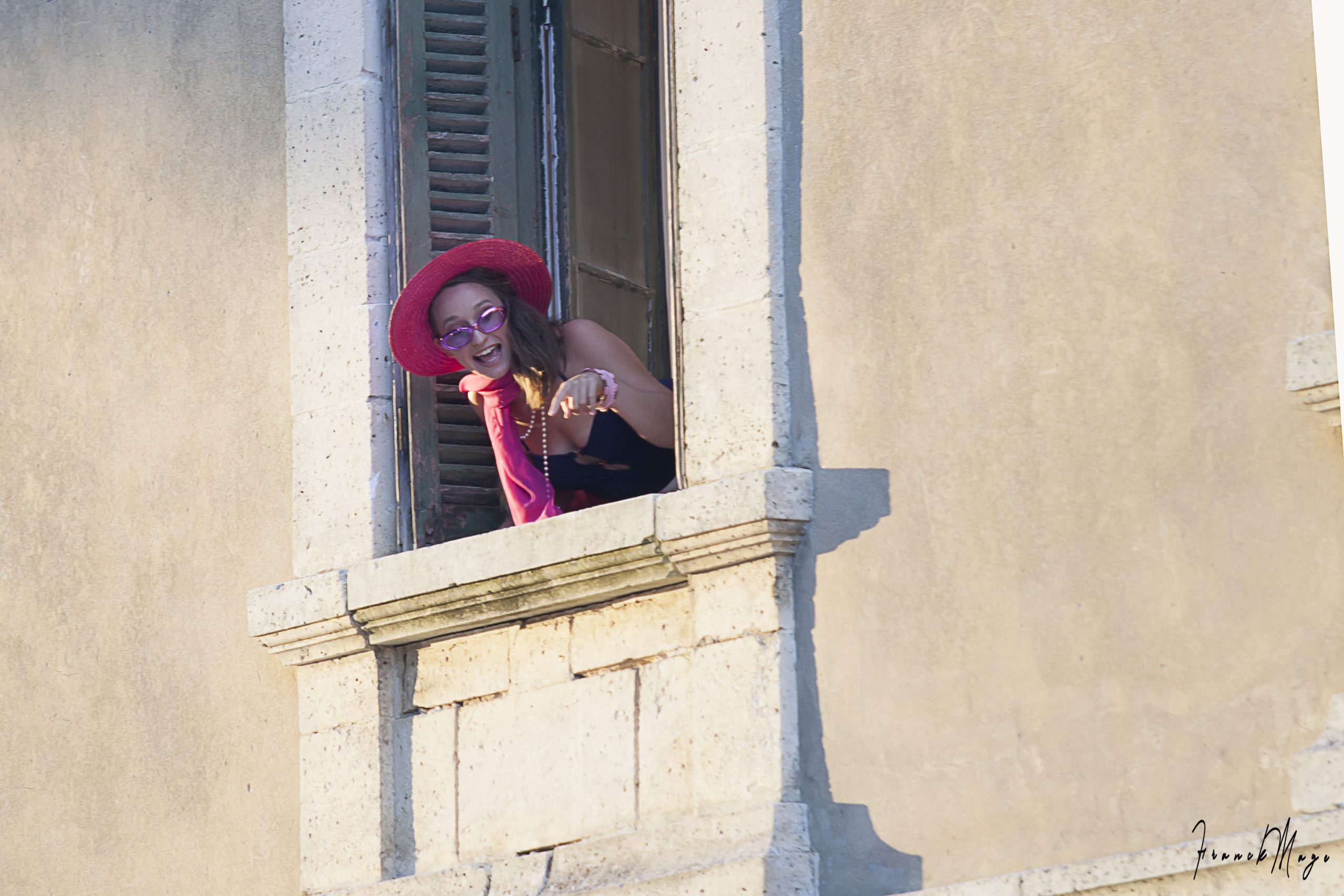 Anaïs de Faria qui apparaît à le fenêtre dans le rôle de Giannetta dans L'elisir d'amore